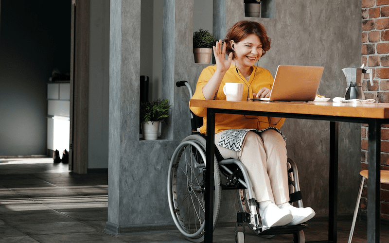 woman in wheelchair using laptop computer