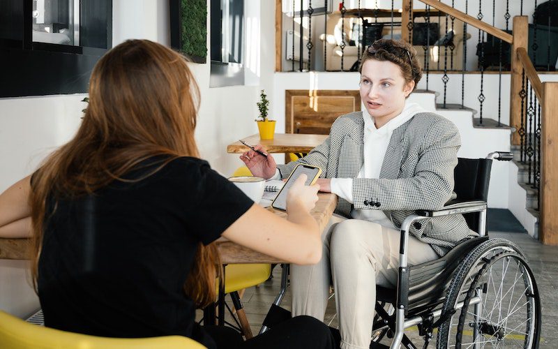 conversation between two people, one in a wheelchair